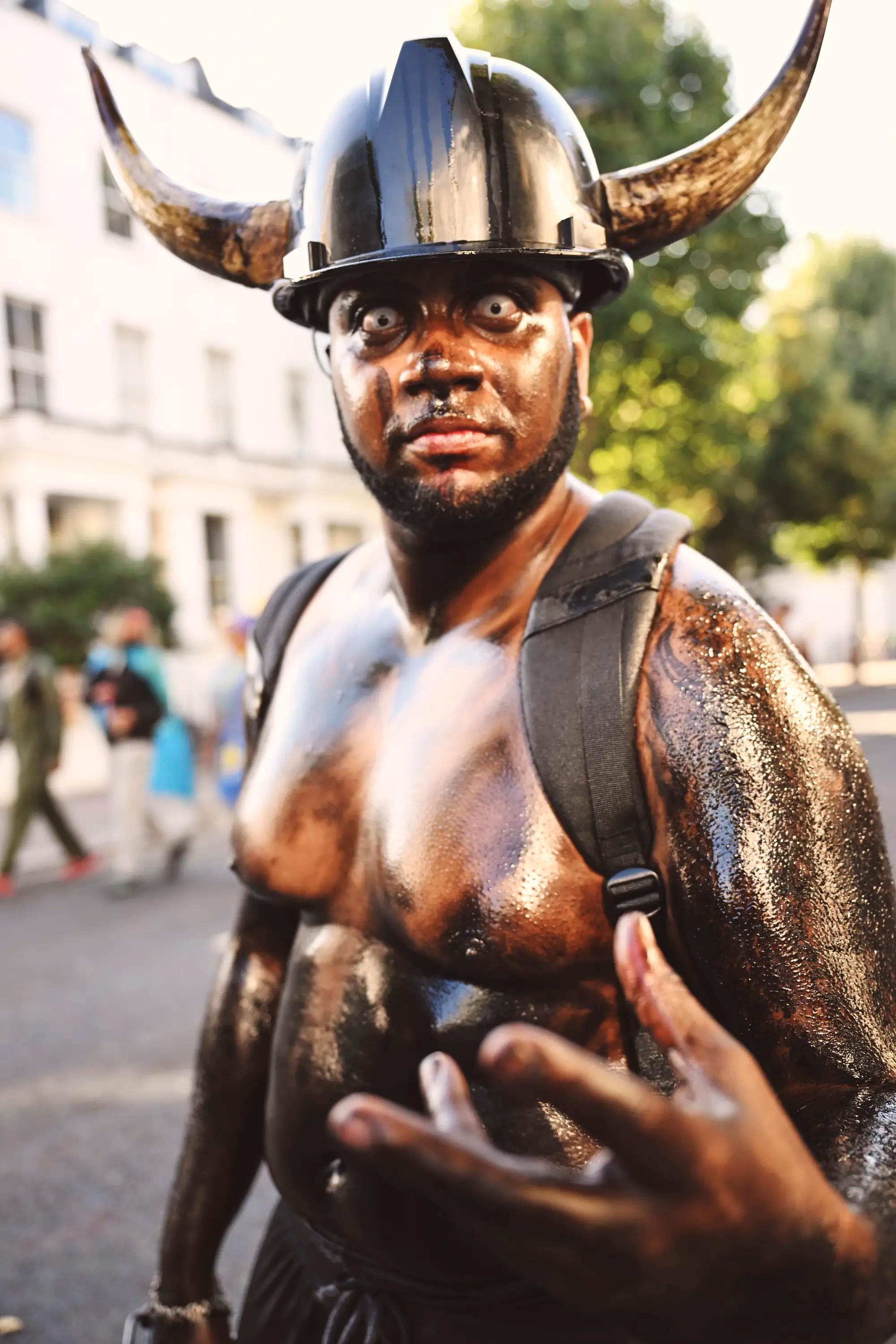 portrait of Jab Jab performer wearing horned helmet and contact lenses during carnival in London