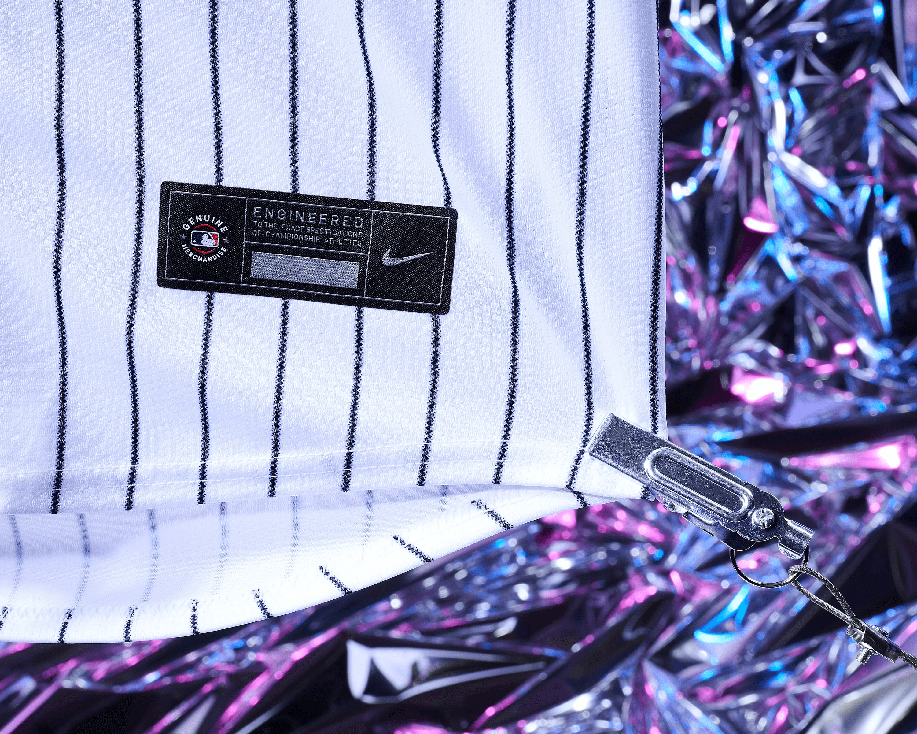 close up of New York Yankees jersey collar, NY logo and button placket against holographic backdrop, product detail photography Manchester