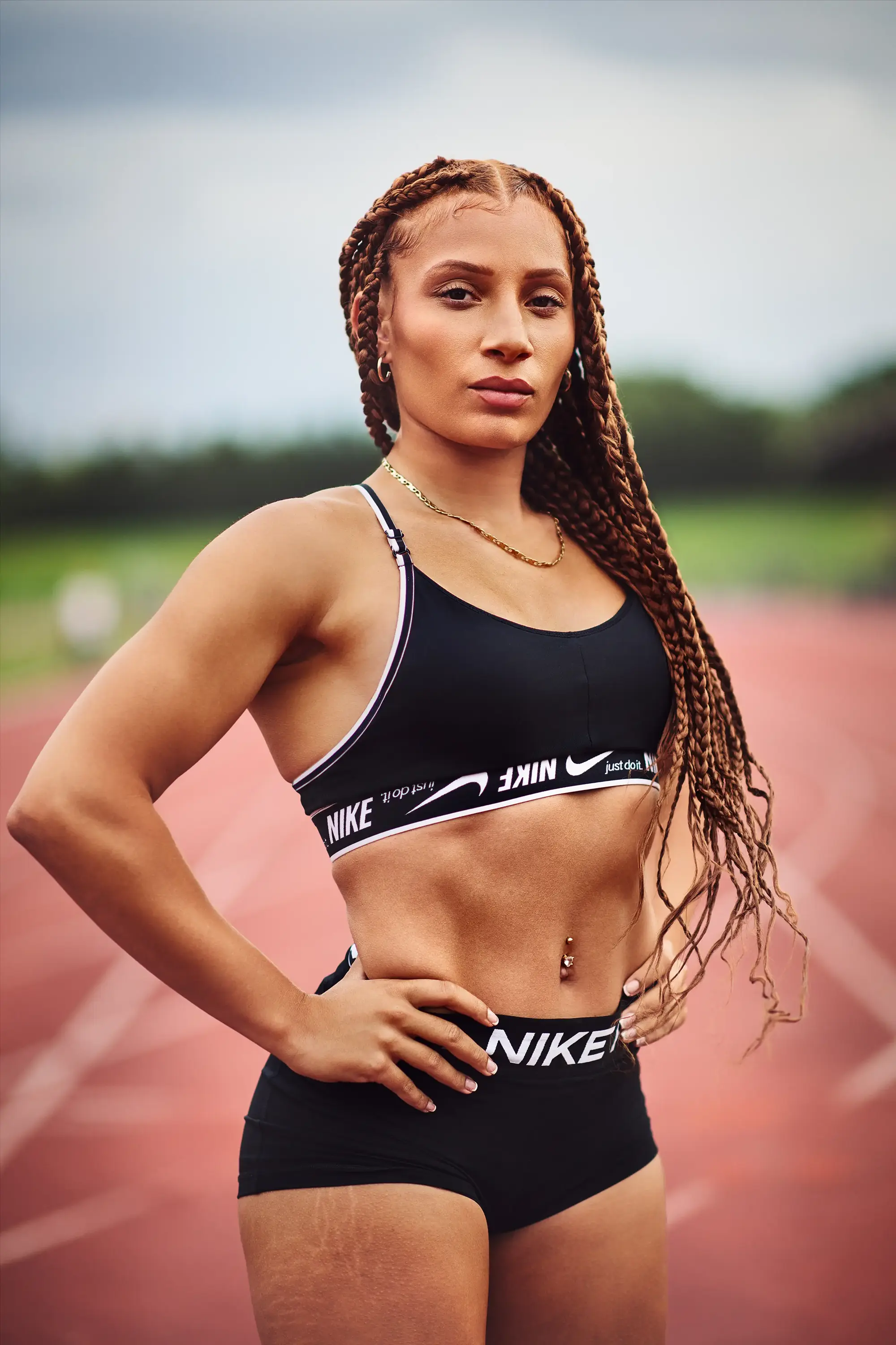portrait d'une athlète en tenue de sport sur une piste d'athlétisme, posture assurée, photographie sportive publicitaire à Londres