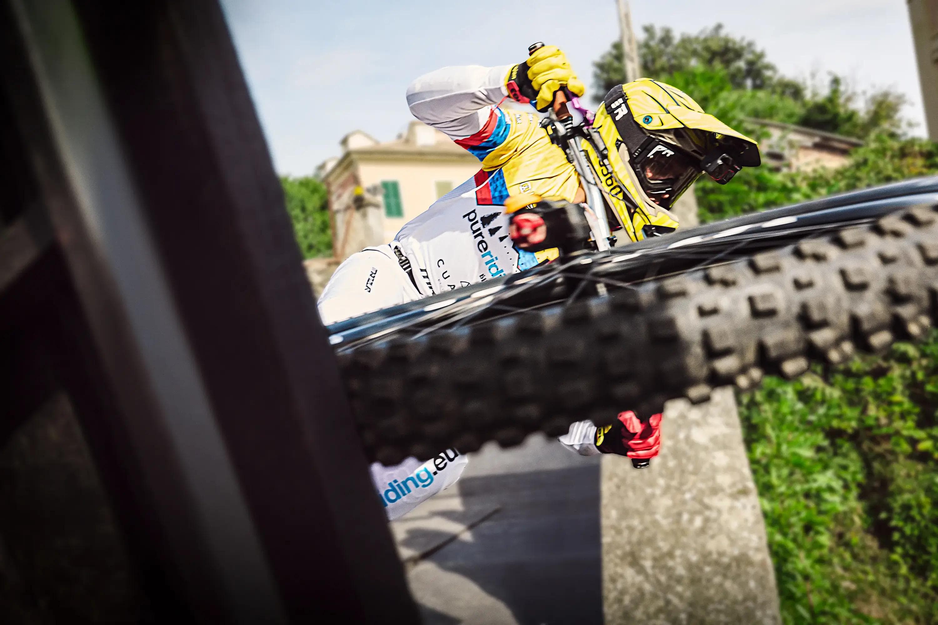 close up downhill rider leaning into turn, motion blur and dynamic framing, mtb action photography