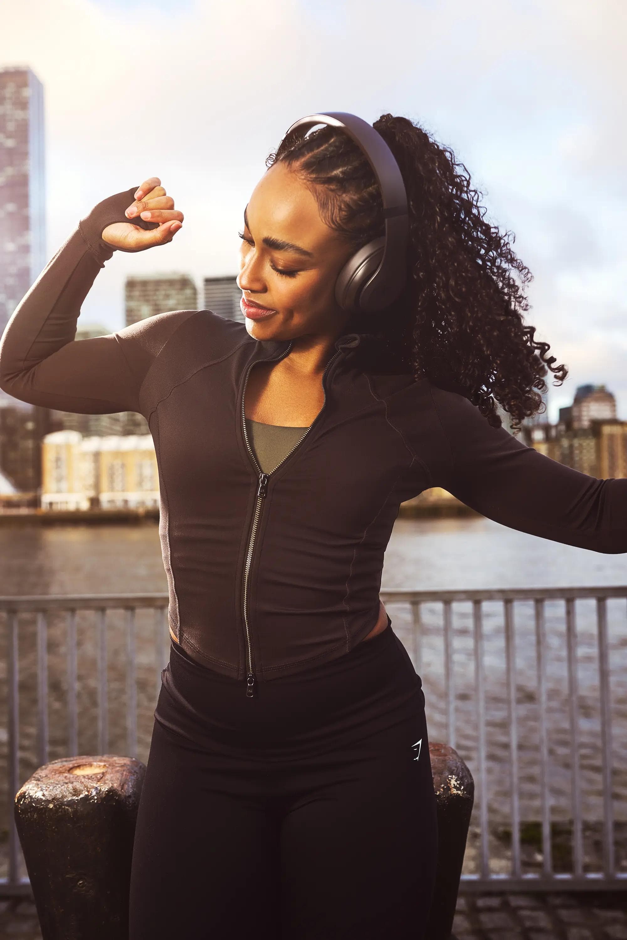 woman stretching wearing headphones fitness lifestyle London natural light