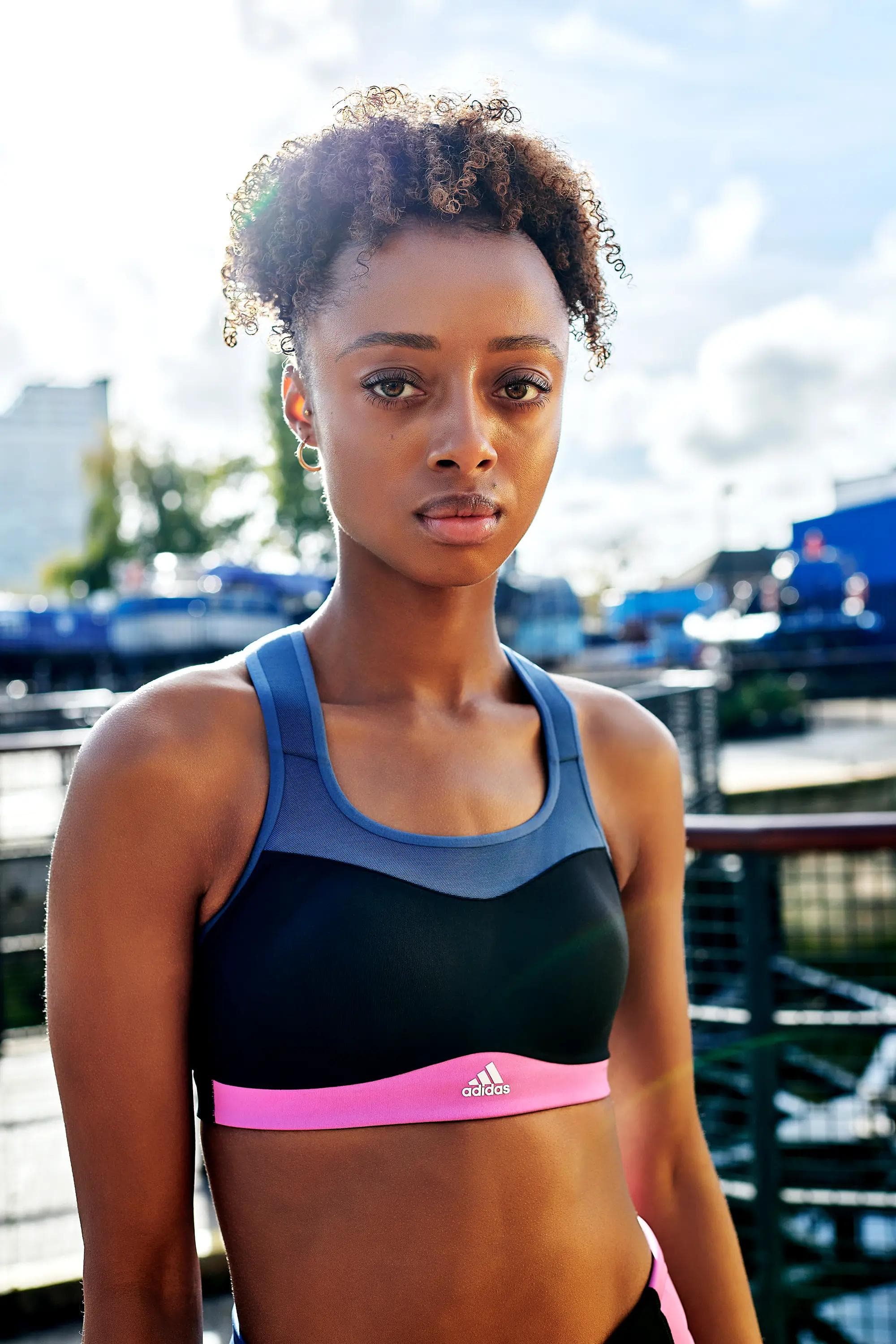 female athlete standing confidently in adidas training outfit beside waterfront, commercial sports photography London